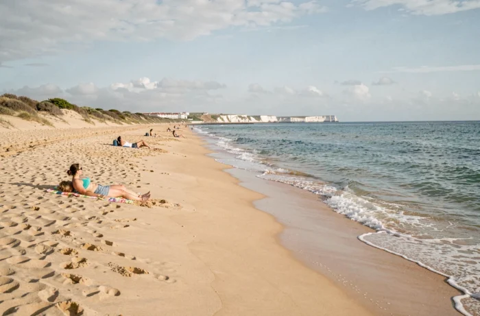 Plage dorée d'Almada au Portugal avec des vacanciers se détendant au bord de l'Atlantique