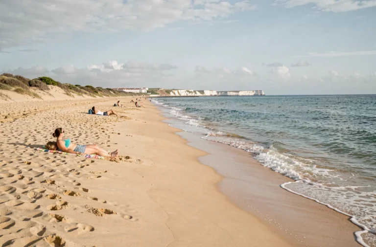 Plage dorée d'Almada au Portugal avec des vacanciers se détendant au bord de l'Atlantique